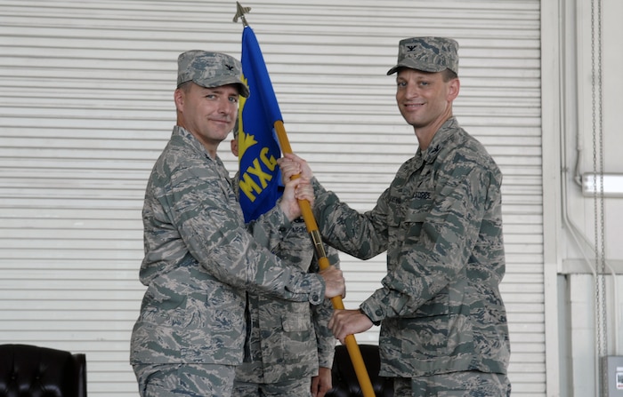 Col. John Wood passes the 437th Maintenance Group guideon to Col. James Clavenna at Nose Dock 2 on Joint Base Charleston, S.C., during the the 437 MXG change of command ceremony Aug. 12, 2010. Command of the group was relinquished from Col. Tammy Livingood, who took command in June 2007 and retired from active military service. Colonel Clavenna comes to Charleston after his previous assignment with the Air Force Fellows Program at the George C. Marshall European Center for Security Studies, Garmisch, Germany. Colonel Wood is the 437th Airlift Wing commander. (U.S. Air Force photo/Senior Airman Nicole Mickle)