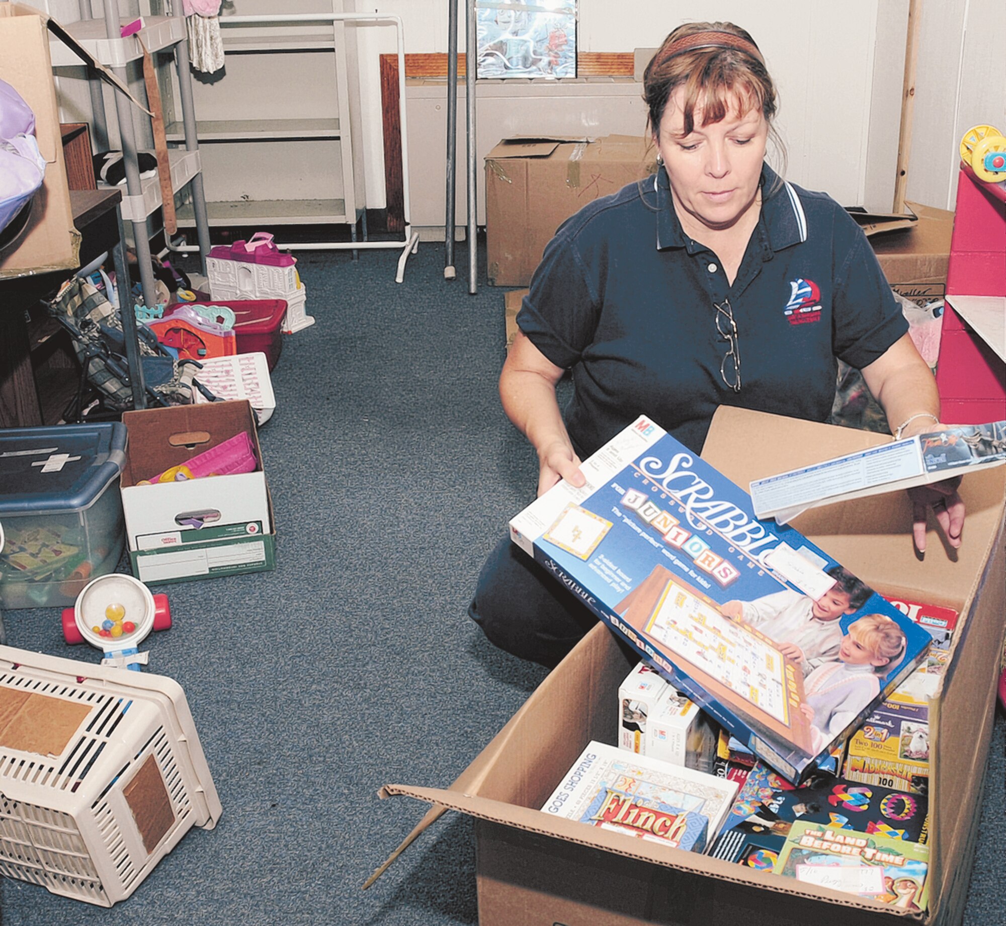 Karen Ray, wife of Lt. Col. Stephen Ray, 20th Air Force, packs board games and other children’s toys in  preparation for the Keesler Thrift Shop’s move Monday. The new location of the thrift shop, operated by the Keesler Spouses Club, is the old garden center at the corner of Meadows Drive and First Street. A grand opening is 9 a.m. Monday. Hours are 9 a.m.  to 2 p.m. Mondays and Wednesdays. For more information, call 377-3217 or log on to www.keeslerspousesclub.com  (U.S. Air Force photo by Kemberly Groue)