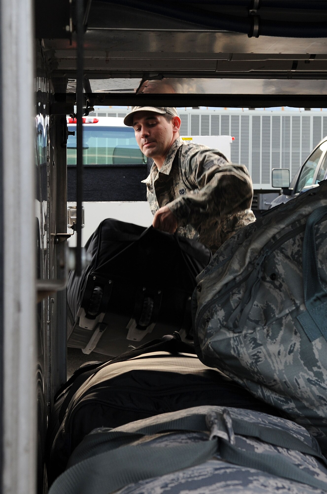 LANGLEY AIRE FORCE BASE, Va. -- Senior Airman Bryan Barnett, 633d Civil Engineer Squadron water and fuels system maintenance specialist, loads his baggage before departing on his deployment to Afghanistan. Airman Barnett and other CE professionals are part of the 877th Expeditionary Prime Base Engineer Emergency Force Squadron, tasked with the construction of forward operating bases for U.S. Central Command.  (U.S. Air Force Photo/Staff Sgt. Christina M. Styer)