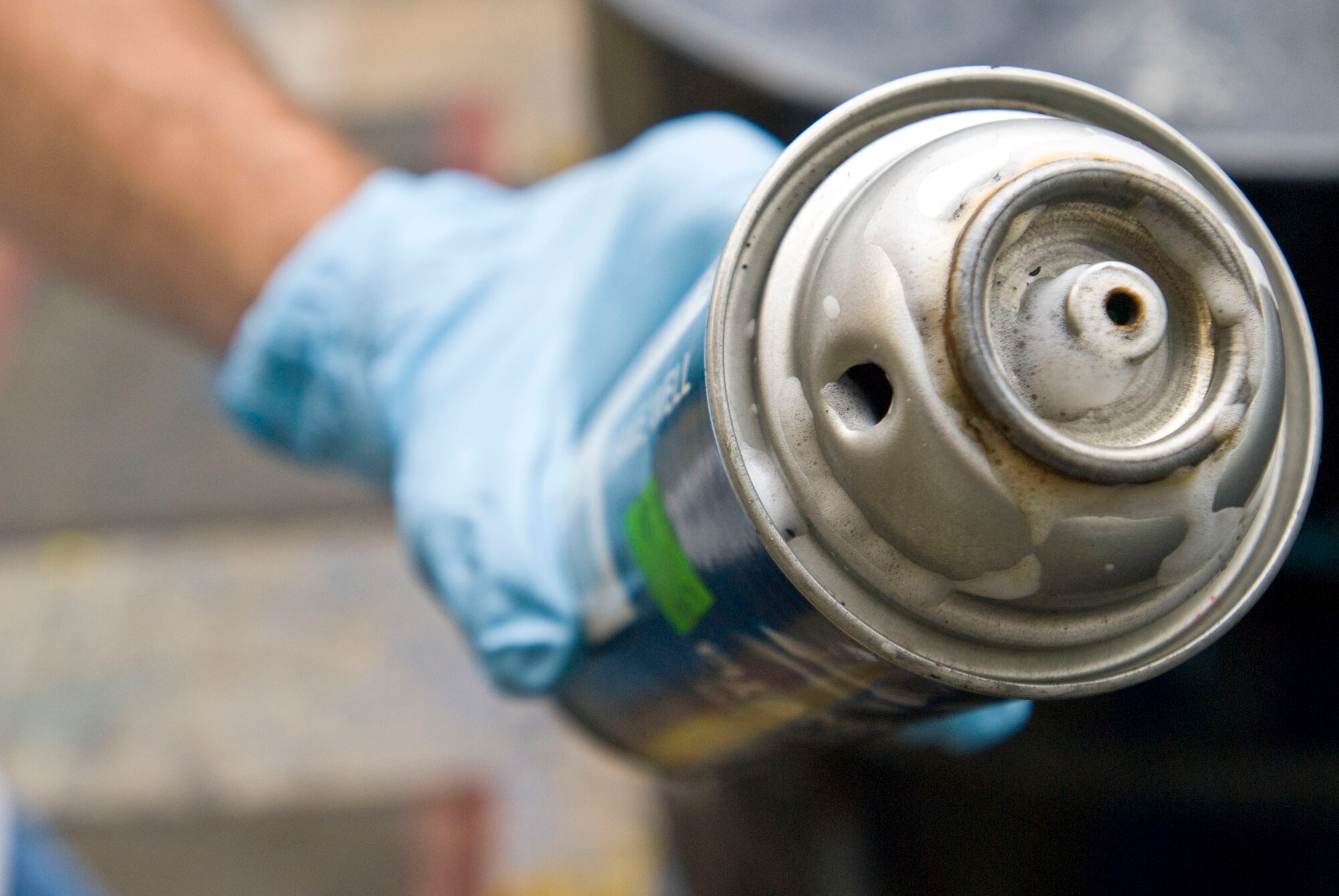 Bill Barrett, 19th Civil Engineer Squadron environmental protection assistant, holds up an empty aerosol can with a punched hole Aug. 12. Punching holes in aerosol cans relieves the pressure and renders them non-hazardous and recyclable. (U.S. Air Force photo by Staff Sgt. Nestor Cruz)