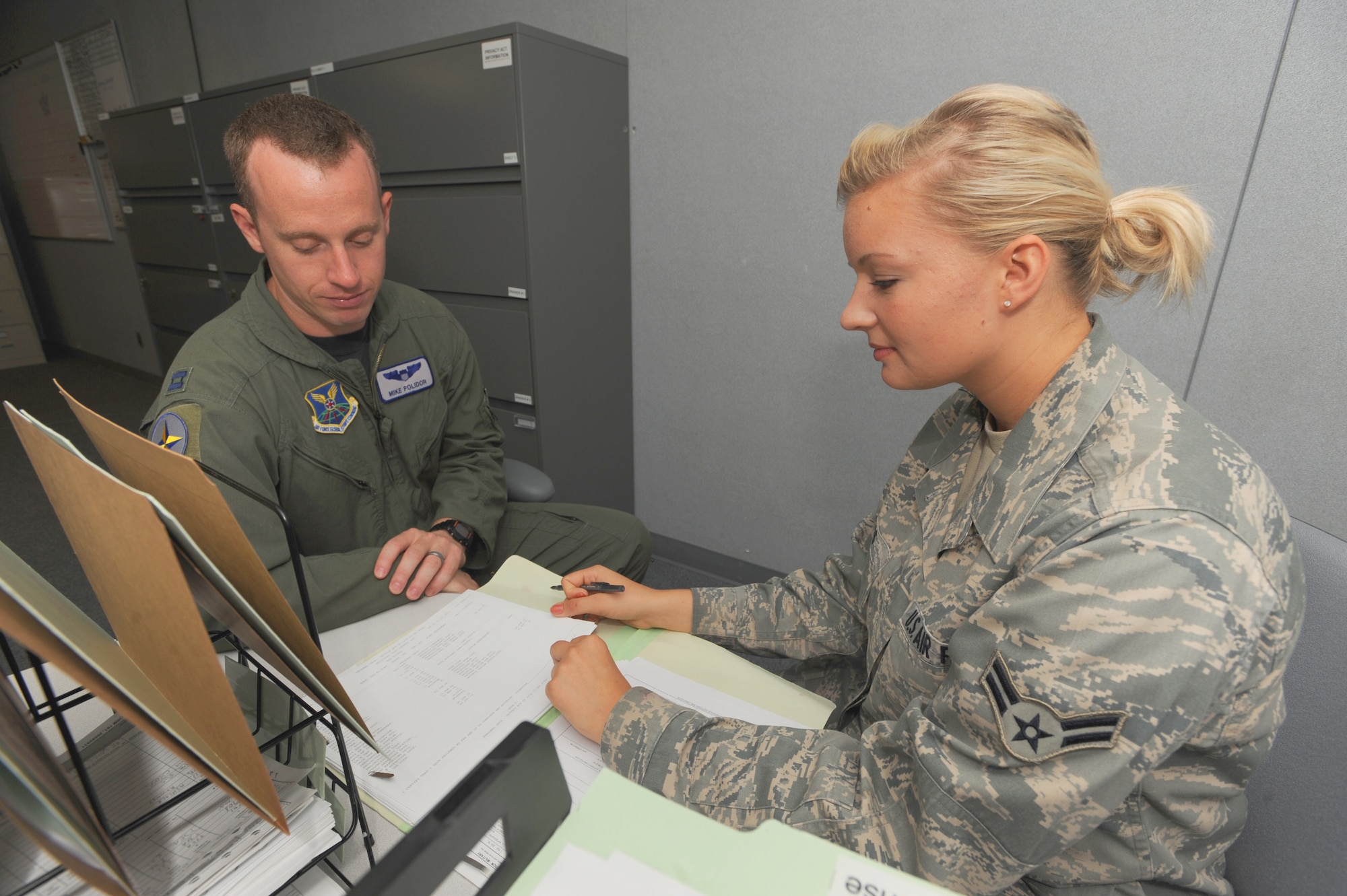 WHITEMAN AIR FORCE BASE, Mo. - Airman 1st Class Ariel Roness, 509th
Operation Support Squadron aviation resource management, goes over the record of  Capt. Mike Polider, a 394 Combat Training Squadron T-38 pilot,
to ensure his training is current, Aug . 17. Airman Roness reviews up to 20 sets of records a day, ensuring all pilots are current and mission ready.(U.S. Air Force photo by Senior Airman Carlin Leslie)
