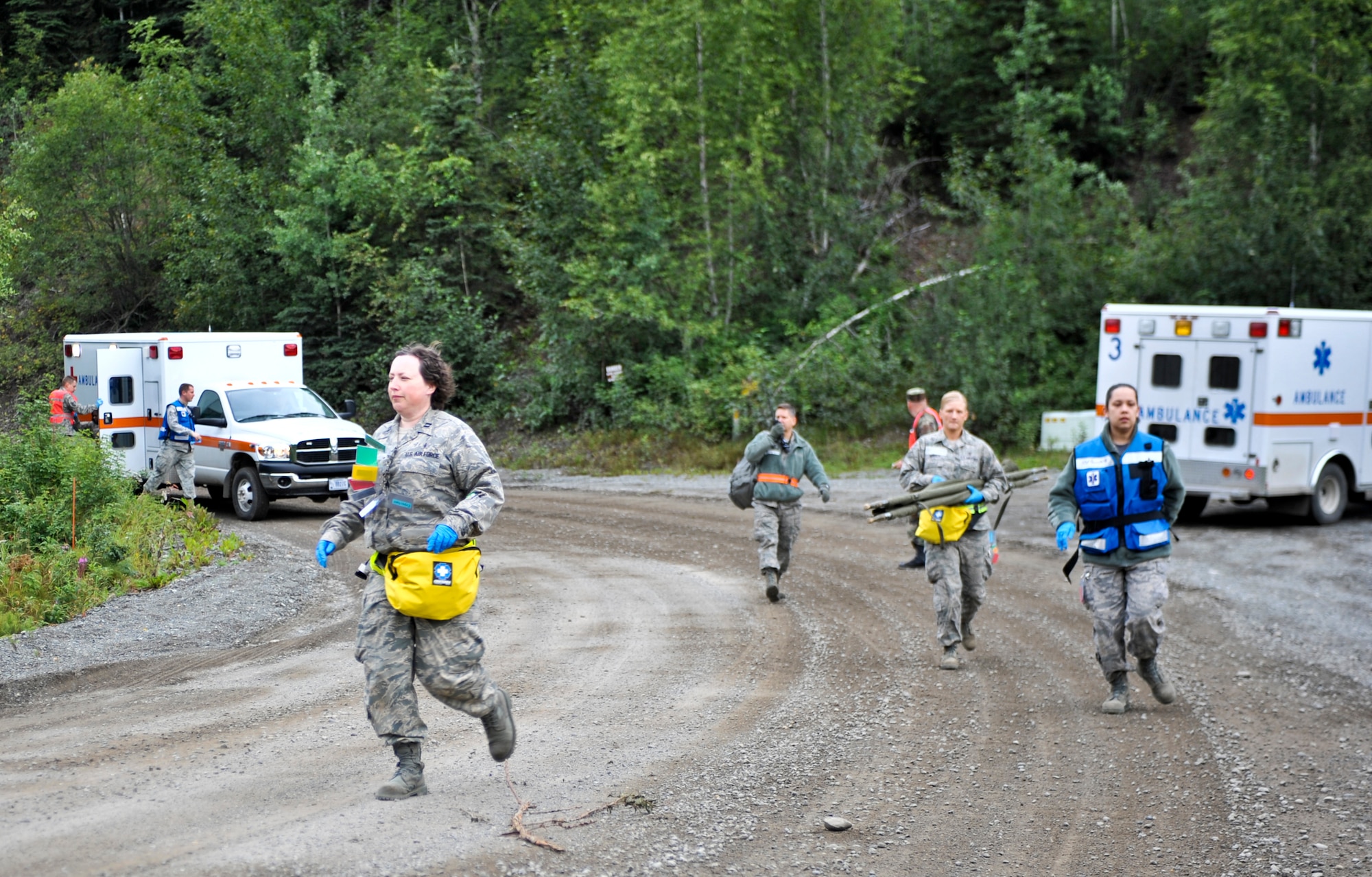 JOINT BASE ELMENDORF-RICHARDSON, Alaska – Airmen run to the aid of “patients” during a simulated bridge collapse scenario, Aug. 12. The five-day Expeditionary Medical Support Training was held for the first time at Joint Base Elmendorf-Richardson, Aug. 9-13. Eighty-one Airmen from around the Pacific Air Forces came to the mandatory pre-deployment training. The EMEDs training is typically held at Brooks City Base in San Antonio. (Air Force photo by Airman 1st Class Christopher Gross)