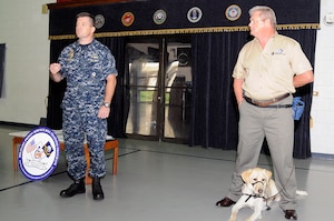 Commanding Officer Navy Cmdr. Ray Drake, left, along with Rick Hairston, president and CEO of Carolina Canines for Veterans, announced that the program expects to begin with seven canines arriving Aug. 31. Since the program's inception in 1996, 10 dogs valued at more than $400,000 have been placed with wounded warriors, allowing disabled veterans more independence. (U.S. Navy photo/Mass Communication Specialist 1st Class Jennifer Hudson)
