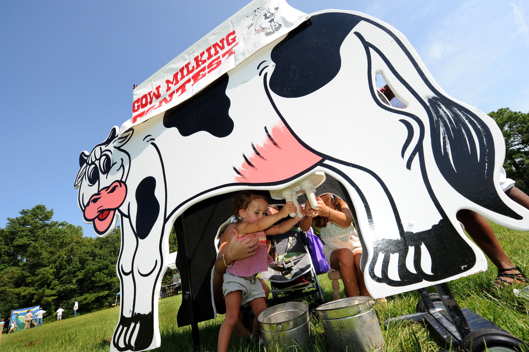 Arianna and Kamryn Skonieczny milk a wooden cow at the Exceptional Family Members Fair on Joint Base Charleston, S.C., Aug. 13, 2010. The Exceptional Family Members Program requires a mandatory enrollment for all families that have special needs dependents. The program ensures that Airmen will not be stationed anywhere which adequate care is not available to their dependents.  Arianna and Kamryn are the daughters of Staff Sgt. Beau Skonieczny, a communication navigation specialist with the 437th Aircraft Maintenance Squadron. (U.S. Air Force Photo/Airman 1st Class Lauren Main) 
