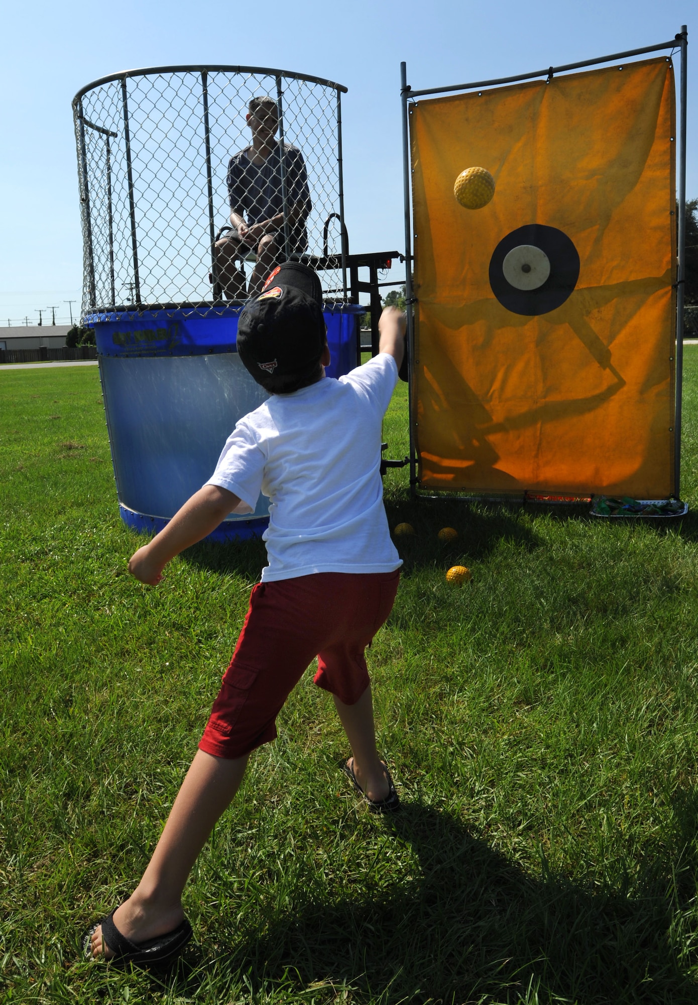 Logan Mills tosses a ball at the dunk tank target at the Exceptional Family Members Fair held at Joint Base Charleston, S.C., Aug. 13, 2010. The fair was comprised of numerous activities and information booths for families that have special needs dependents. The fair was funded by a grant from the Air Force Aid Society. Logan is the son of Master Sgt. Scott Mills, a loadmaster with the 16th Airlift Squadron. (U.S. Air Force Photo/Airman 1st Class Lauren Main)
