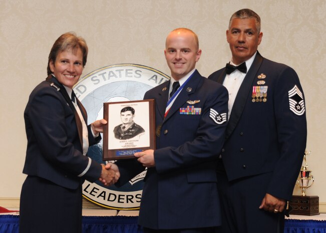 Col. Martha Meeker, left, and Chief Master Sgt. Lance Gomes, right, present Staff Sgt. Wesley Spring with the John L. Levitow Award during the Airman Leadership School Class 10-F graduation at the Charleston Club here Aug. 12. The award is given for a student's exemplary demonstration of excellence both as a leader and a scholar. Approximately 30 Airmen graduated from the class and will now embark on the next phase of their enlisted careers as supervisors. Colonel Meeker is the Joint Base Charleston commander, Chief Gomes is the 628th Force Support Squadron superintendent and Sergeant Spring is a loadmaster with the 15th Airlift Squadron. (U.S. Air Force photo/Airman 1st Class Lauren Main)