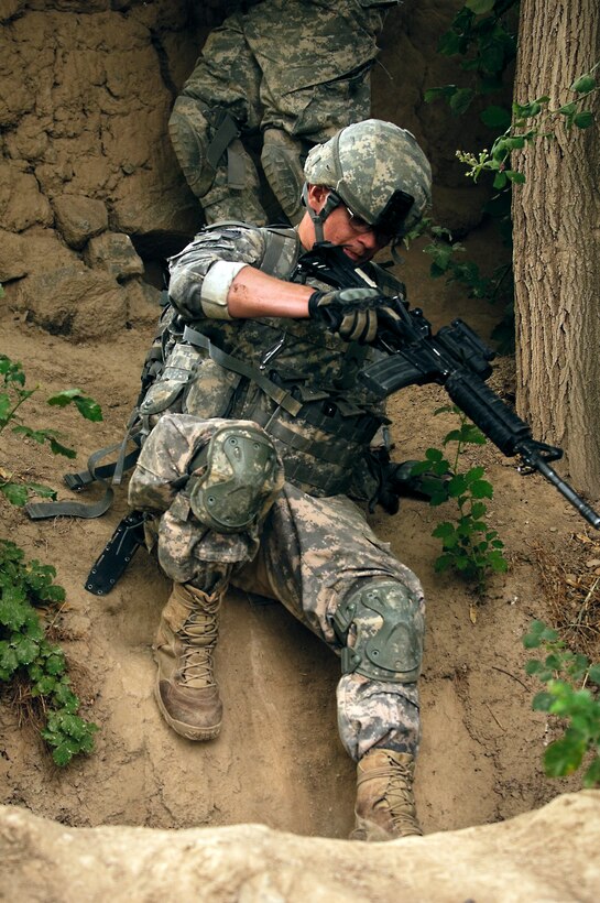 U.S. Army Pfc. Christopher Dudick climbs into a ravine during a dismounted patrol near Combat Outpost Mizan, Mizan District, Zabul province, Aug. 16, 2010. Dudick, a medic, is assigned to the 3rd Platoon, Fox Company, 2nd Squadron, 2nd Stryker Cavalry Regiment.