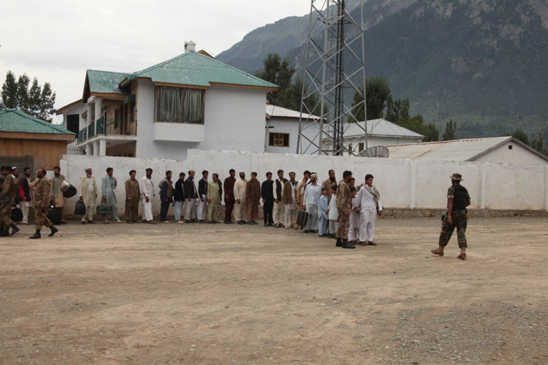 Pakistani citizens await transport on Marine Super Stallion (CH-53E) helicopters to camp sites prepared for displaced flood victims during humanitarian relief efforts in the Khyber-Pakhtunkhwa province, Pakistan (formerly known as the Northwest Frontier province).