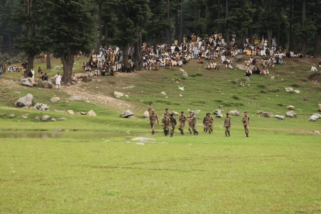 Pakistani citizens await transport on Marine Super Stallion helicopters to camp sites prepared for displaced flood victims during humanitarian relief efforts in the Khyber-Pakhtunkhwa province, Pakistan (formerly known as the Northwest Frontier province).
