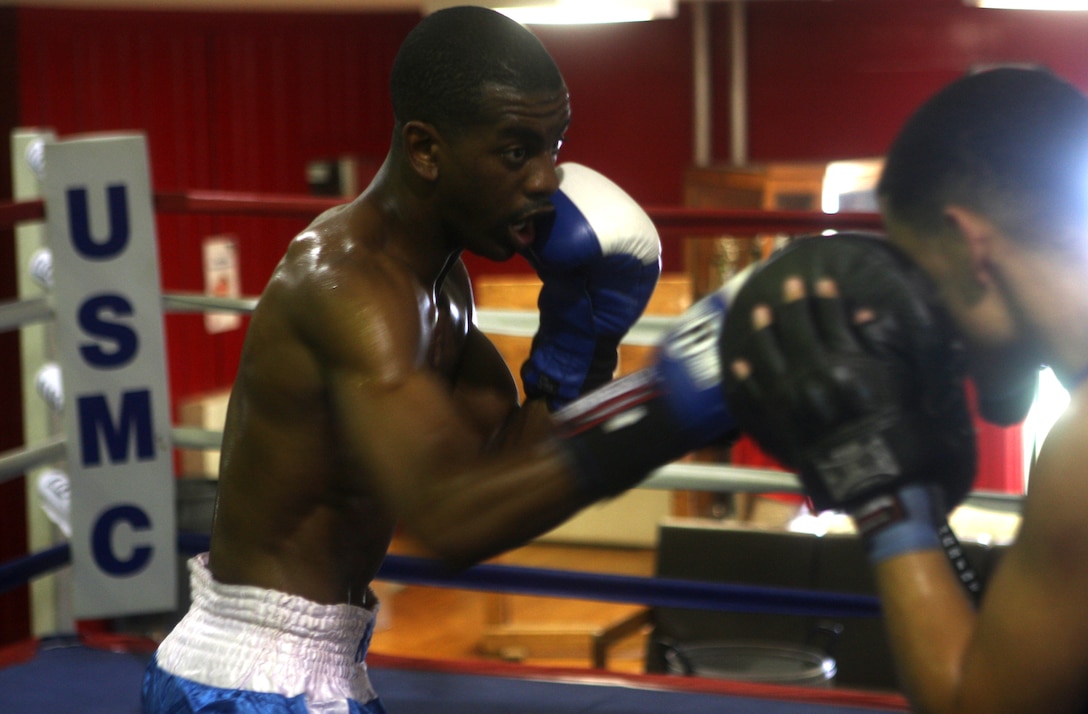 Cpl. Jamel Herring (left), a boxer with the All-Marine Boxing Team aboard Marine Corps Base Camp Lejeune, practices punching techniques with his teammate Lance Cpl. Tommy Roque, at the AMBT gym, Aug. 18. Herring and Roque, along with Cpl. Damarias Russell, will be competing in the upcoming 53rd Conseil International du Sport Militaire's (International Military Sports Council's) World Military Boxing Championship to be held aboard Camp Lejeune in October.