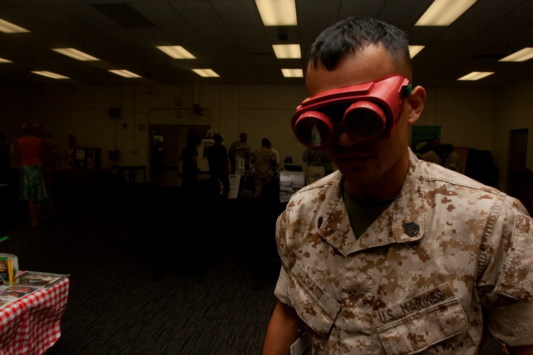 Staff Sgt. John Chang, U.S. Marine Corps Forces, Pacific’s information assurance chief, uses “beer goggles” to simulate the effects alcohol has on a person’s vision Aug. 18 during the MarForPac Health and Wellness Fair at the MarForPac headquarters building, here. ::r::::n::	“I can’t touch anything without missing it a couple times first,” Chang said. “You really don’t understand how alcohol affects your vision until you experience it with a sober mind.”::r::::n::Chang attended the event to acquire and bring new information to his Marines in order to teach them healthy decision-making skills.