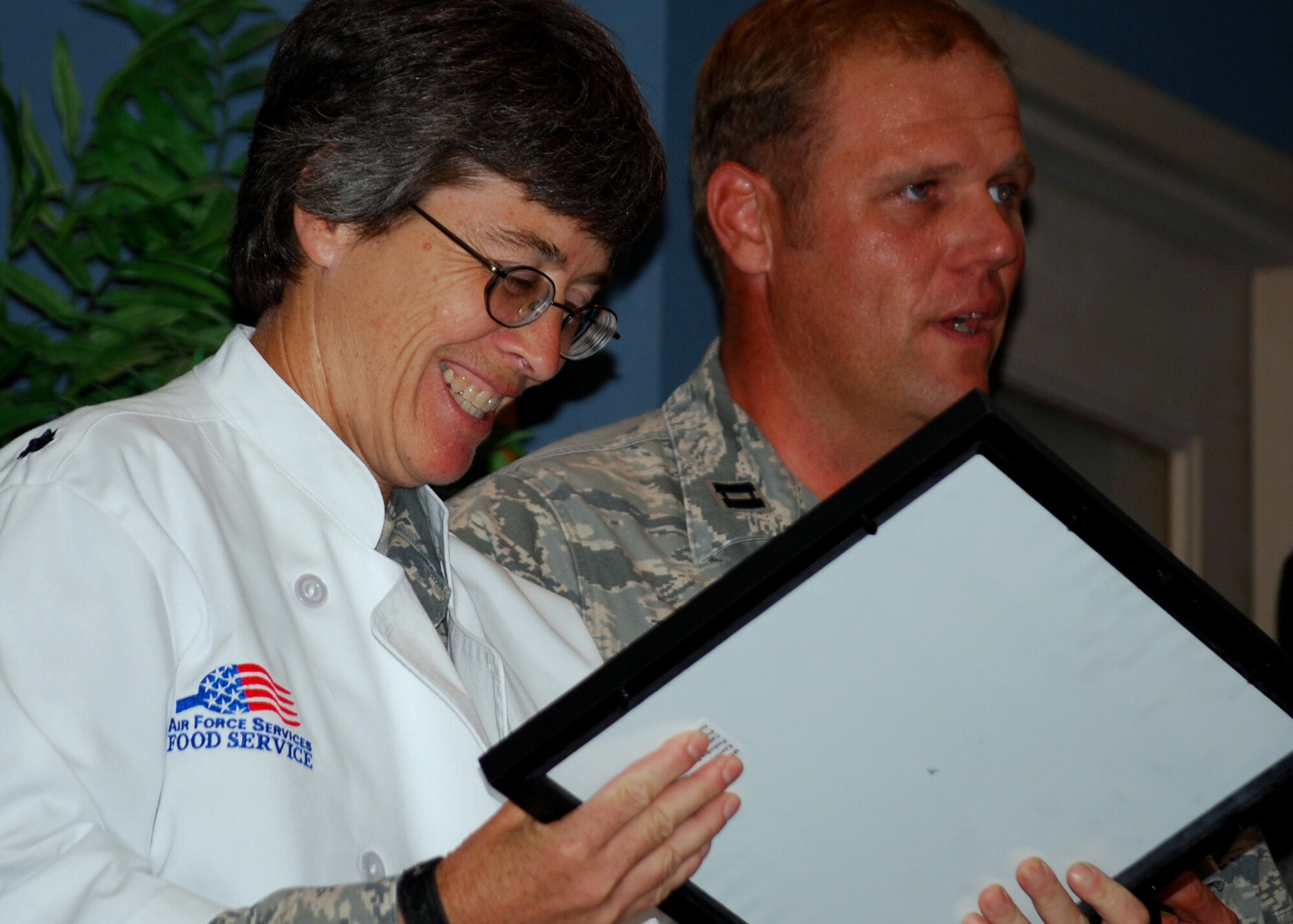 Lt. Col. Patricia Brewer, 919th Mission Support Group, admires a plaque presented to her by Capt. Michael McGee on behalf of the 919th Security Forces Squadron. The 919th Special Operations Wing held a going-away ceremony for her during the August unit training assembly. Colonel Brewer moves on to Beale AFB, Calif. in September. (U.S. Air Force photo/Tech. Sgt. Cheryl Foster)
