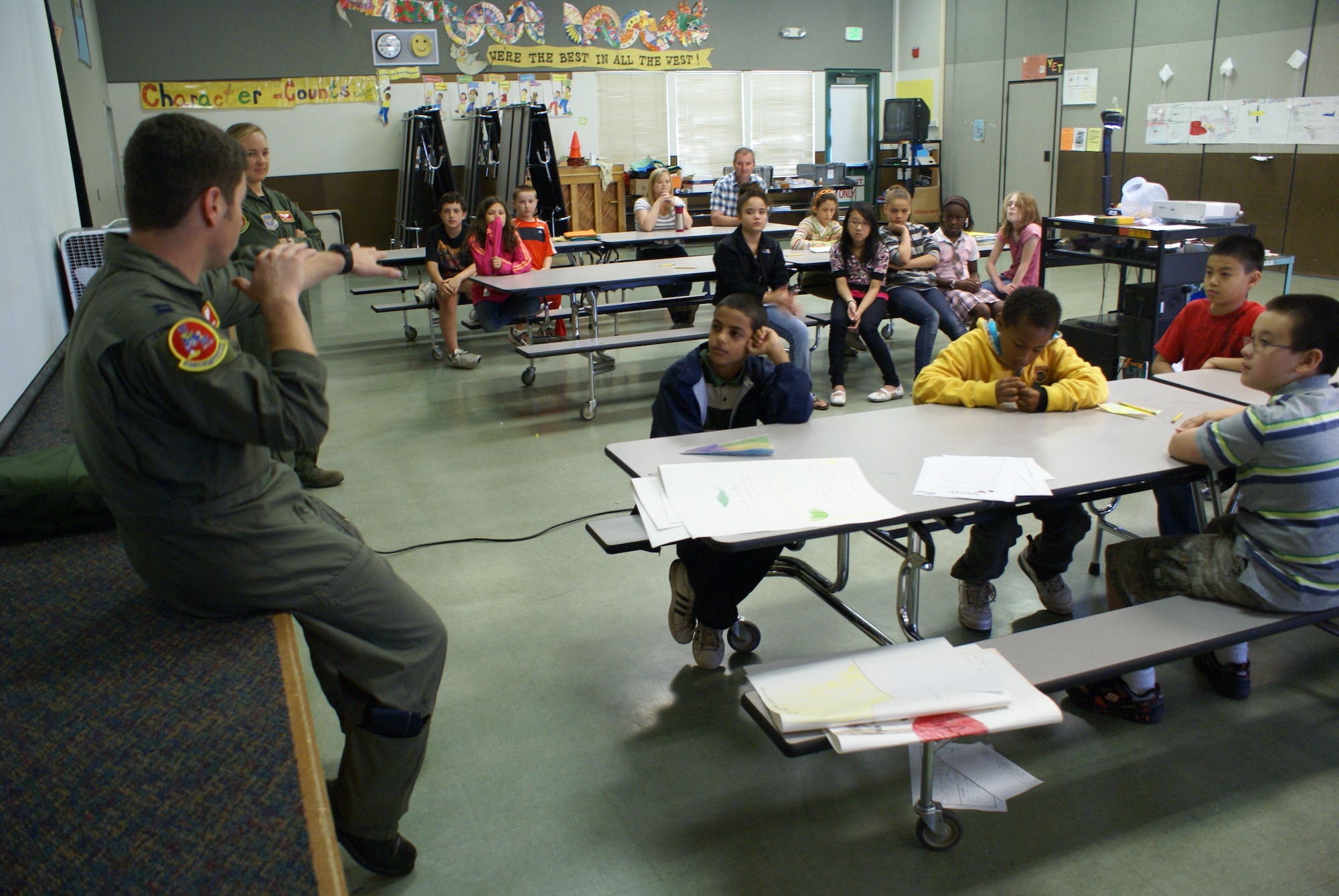 Capts. John Miranda and Emily Yturralde, both 10th Airlift Squadron pilots assigned to Joint Base Lewis-McChord, Wash., speak to a summer science camp class of fifth grade students at Delong Elementary School in Tacoma, Wash., Aug. 18. The pilots spoke to the students about the principles of flight and what it takes to become a pilot. (U.S. Air Force Photo/Airman Leah Young)