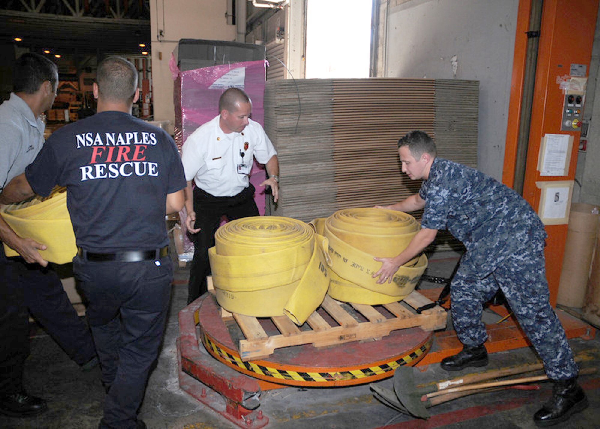 Logistic Specialist 2nd Class Vitali Toptchenko, NSA Naples Lead Fire Inspector Hanz Christian, and Italian national firefighters Maurazio Patrone and Alessio Storto load a pallet of firefighting equipment destined for Russia to help combat wildfires Aug.11, 2010. U.S. Navy officials routinely provides foreign humanitarian assistance in times of crisis, in the same manner as many nations around the world. (U.S. Navy photo/Petty Officer 3rd Class Kristopher Regan)