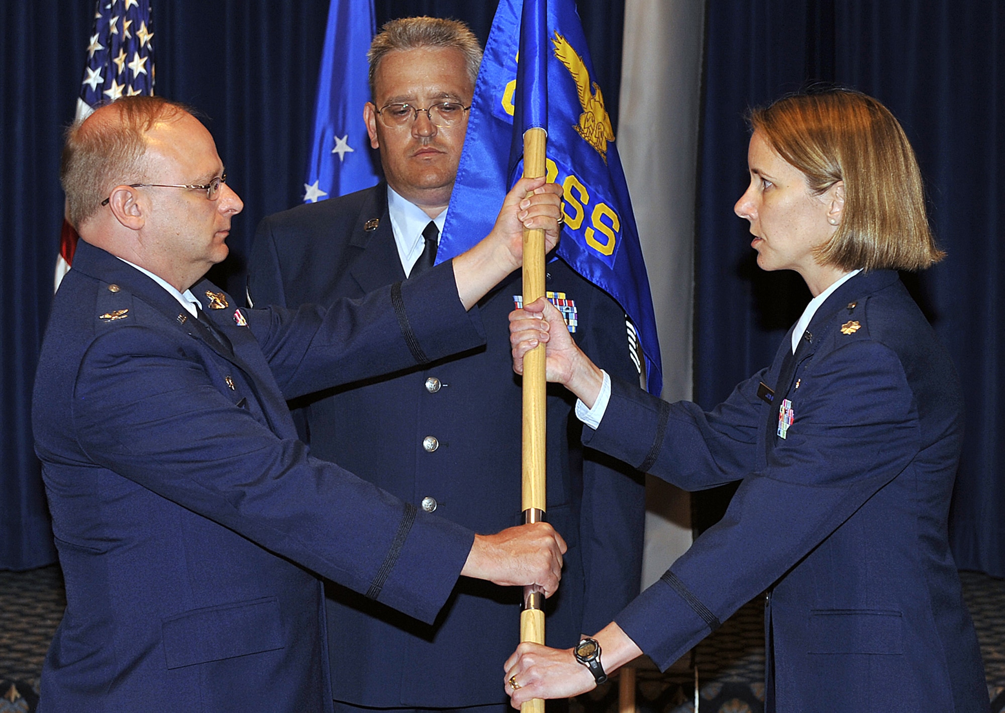 Col. Kurt D. Jones (left) passes the 302nd Operations Support Squadron guidon to Lt. Col. Jennie Johnson during an assumption of command ceremony Aug. 8 at Peterson Air Force Base, Colo. Colonel Johnson, an Air Force Reservist, assumed command of the unit directly after the squadron's standup ceremony. Before becoming a squadron, the organization was an operations support flight. After the ceremony, Colonel Johnson addressed the audience including 302nd OSS members: "To the men and women of the 302nd OSS: Commanders come and go, but you are the heart of the unit." Colonel Johnson is a senior C-130 Hercules navigator with more than 1,400 flying hours. Colonel Jones, an Air Reserve Technician, is the commander of the 302nd Operations Group, the parent organization to the 302nd OSS. (U.S. Air Force photo/Larry Hulst)