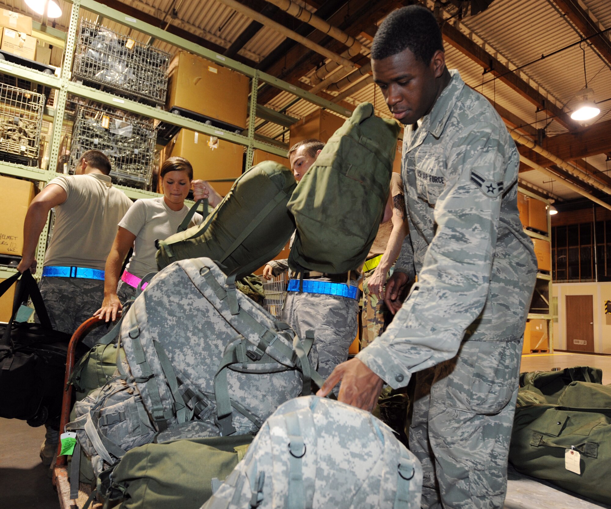 Team McConnell Airmen load mobility bags onto designated carts inside Building 1090 during an operational readiness exercise Aug. 16, 2010, McConnell Air Force Base, Kan.  Airmen serve as augmentees in the 22nd Logistics Readiness Squadron where they help process deploying personnel, build pallets and load cargo. Ensuring tasked Airmen deploy quickly and efficiently is a crucial impact element of the wing’s mission.  (U.S. Air Force photo/Airman 1st Class Andrea Salazar)