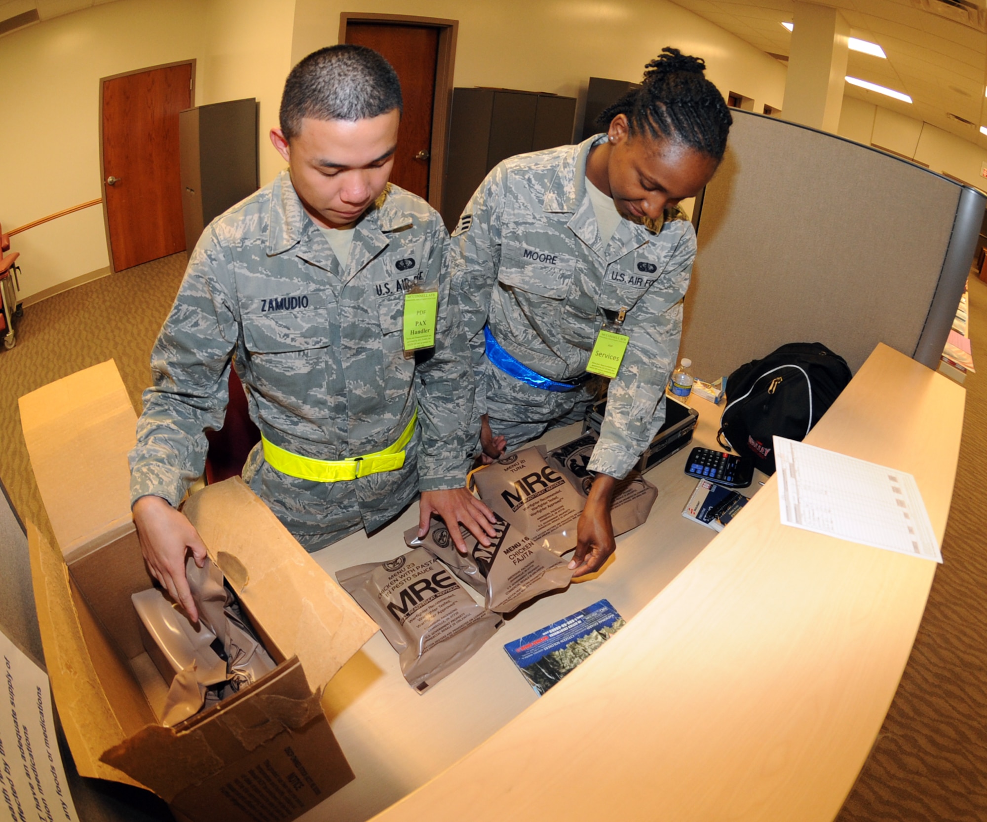 Airman 1st Class Almyr Zamudio, 22nd Force Support Squadron food services apprentice and Senior Airman Tanisha Moore, 22nd FSS accounting journeyman, set up Meals Ready-to-Eat for Airmen processing through a mobility line during an operational readiness exercise Aug. 16, 2010, McConnell Air Force Base, Kan.  The meals were intended for personnel deploying to a forward air base in the United States. The 22nd FSS members are trained to provide food services and lodging under simulated wartime conditions.  (U.S. Air Force photo/Airman 1st Class Andrea Salazar)