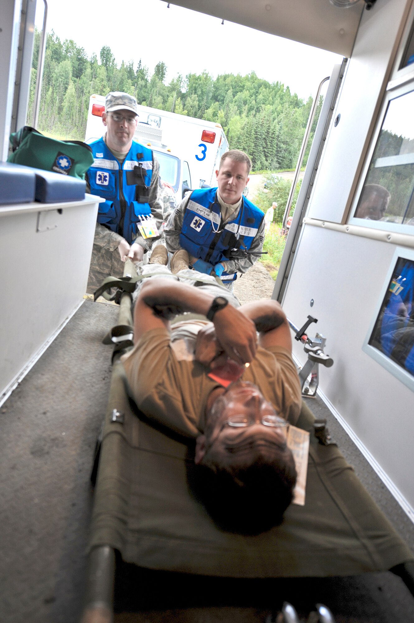 Participants in an Expeditionary Medical Support Training exercise load a "patient" into the back of an ambulance during a simulated bridge collapse scenario Aug. 12, 2010, at Joint Base Elmendorf-Richardson, Alaska. (U.S. Air Force photo/Airman 1st Class Christopher Gross)