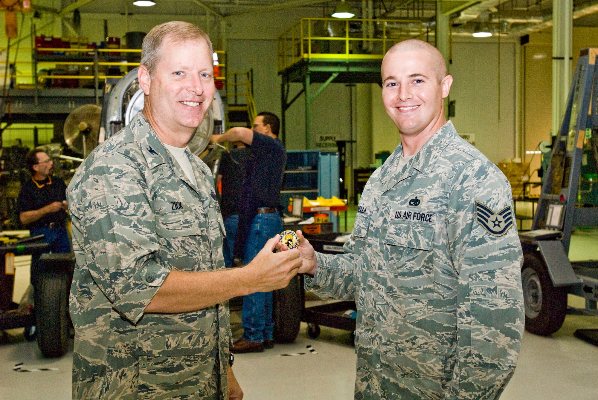 Col. Michael Zick, 19th Airlift Wing vice commander, presents a coin Aug. 18 to Staff Sgt. Christopher Borella, a 19th Maintenance Group quality assurance inspector, for his selection as the Combat Airlifter of the Week. Sergeant Borella discovered a technical order omission and authored a technical manual change recommendation, saving Team Little Rock several training man hours per task and avoiding damage to base aircraft. (U.S. Air Force photo by Staff Sgt. Nestor Cruz)