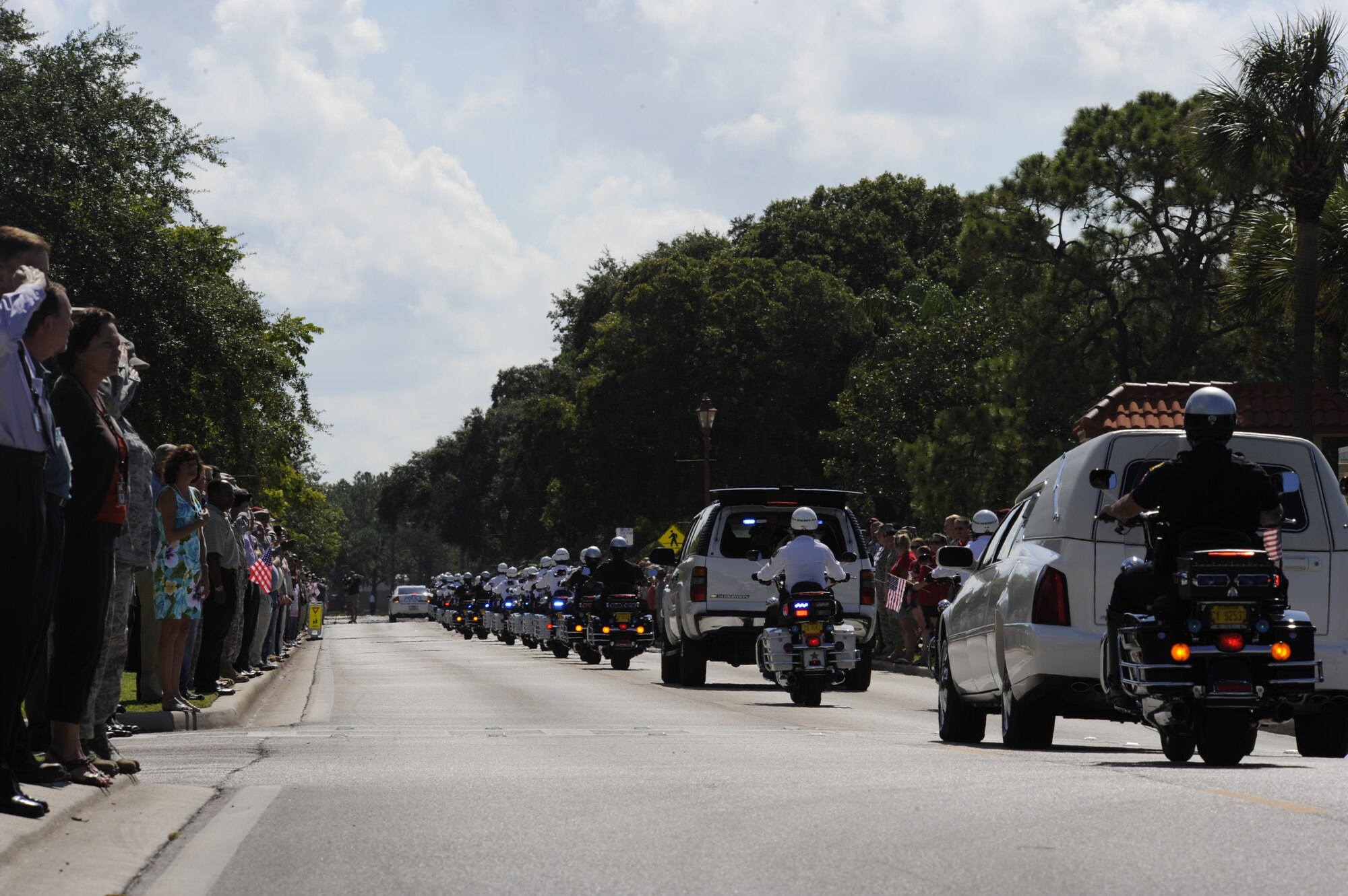 Servicemembers and civilians at MacDill Air Force Base show their respect by saluting or placing their hand over their heart during the precession of fallen solider Private 1st Class Paul O. Cuzzupe II along Florida Keys Avenue, Aug 18, 2010. Private Cuzzupe, 23,  died Aug. 8 in Akhtar-Mohammad-Khan, Afghanistan, of wounds sustained when insurgents attacked his unit using an improvised explosive device.  He was assigned to the 3rd Squadron, 2nd Stryker Calvary Regiment, Vilseck, Germany. (U.S. Air Force photo by: Staff Sgt. Angela Ruiz)
