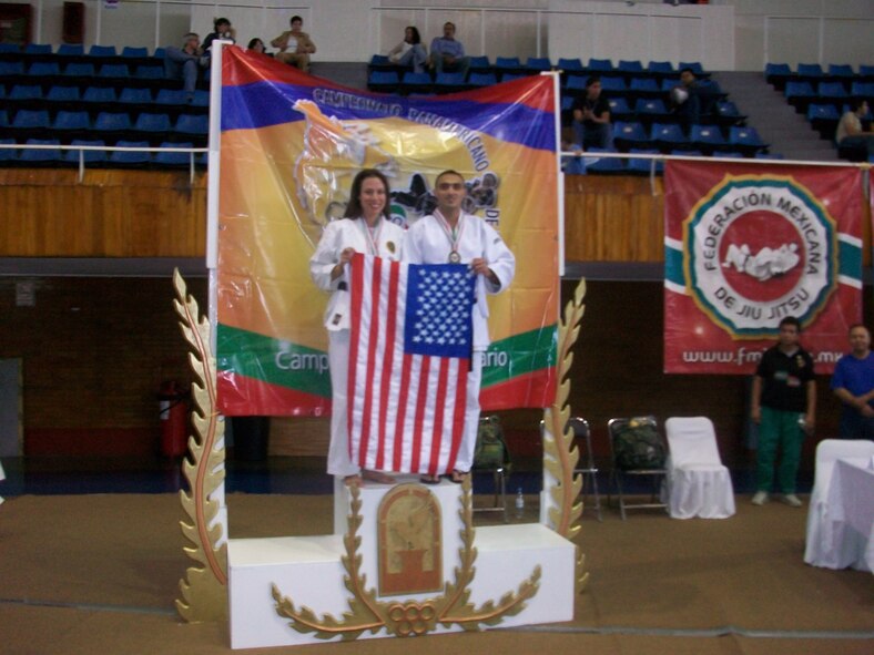 Airman 1st Class Geanny Hernandez-Quiala, 436th Logistics Readiness Squadron, and Sarah Stantone hold the United States flag as they celebrate their victory in the Pan American Open Championships in July. The two took the gold medal in the self-defense competition. (U.S. Air Force photo courtesy photo/Released)