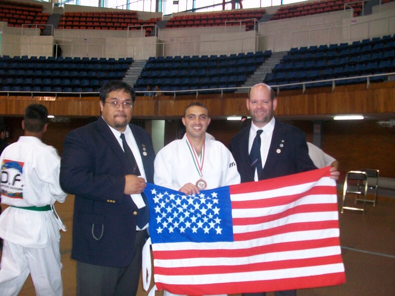 Airman 1st Class Geanny Hernandez-Quiala, 436th Logistics Readiness Squadron, poses with the United States Flag to celebrate his victory in the Pan American Open Championships in July. Airman Hernandez-Quiala won the bronze medal in the free-fight competition in the 69 kilogram division. (U.S. Air Force photo courtesy photo/Released)