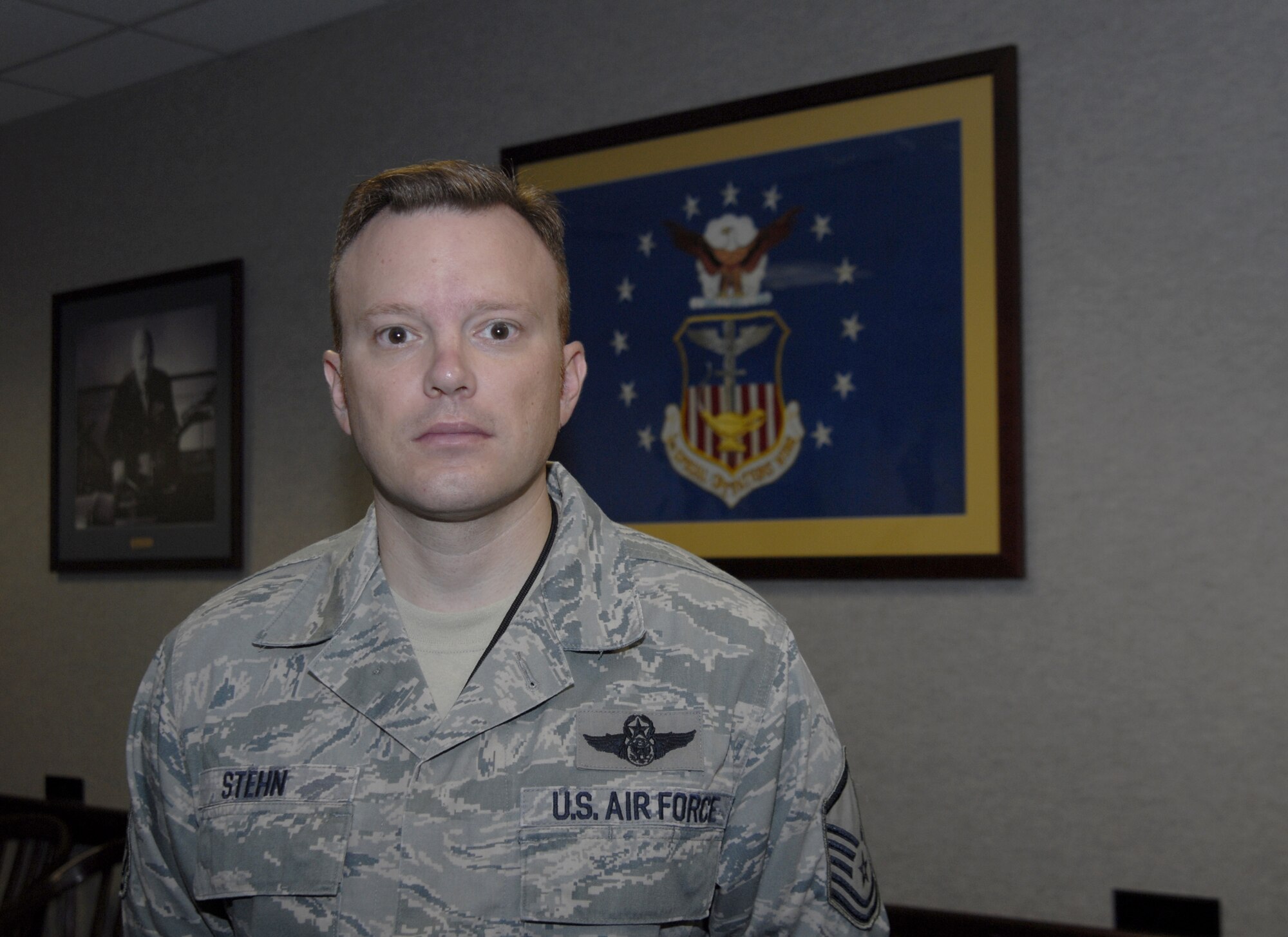 Master Sgt. Jeffrey Stehn, 1st Special Operations Wing Plans and Programs mission planner, poses in front of the Air Force and 1st SOW flag at the wing conference room at Hurlburt Field, Fla., Aug. 18, 2010. Sergeant Stehn was selected for this week's "Tip of the Spear" spotlight. (DoD photo by U.S. Air Force Airman 1st Class Joe McFadden) 