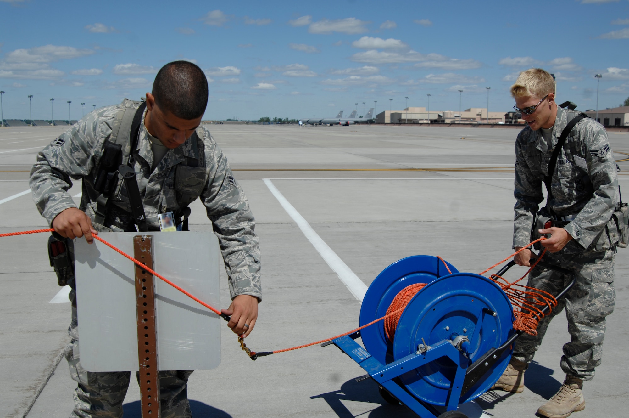 Airman 1st Class Erik Ippel, 22nd Security Forces Squadron installation security constable, and Airman 1st Class Matthew Light, 22nd Security Forces Squadron entry controller, set up a restricted area on a flightline Aug. 16, 2010, at an exercise location. The perimeter was set up as part of a historical operational readiness exercise that required McConnell Airmen to actually deploy to alternate locations.  (U.S. Air Force photo/Senior Airman Abigail Klein)