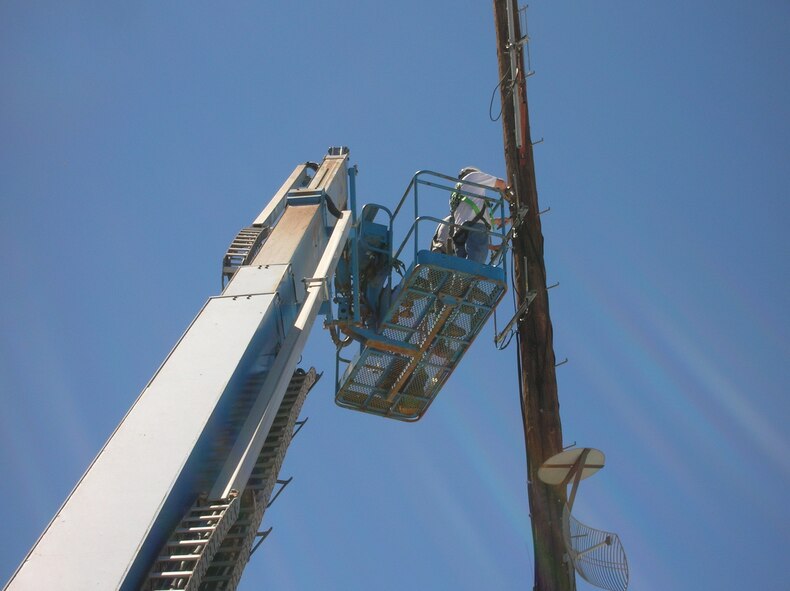 HOLLOMAN AIR FORCE BASE, N.M. -- TollTest contractors install the receiving antennae for a new automated gas and electric meter reading system here. The Air Force is currently funding over $5 million in energy conservation projects at Holloman. The projects include upgrading the lighting in hangars and high-bay facilities, converting office lighting to more efficient lighting, installing occupancy sensors for lighting and installing meters on all buildings that are more than 35,000 square feet. (Courtesy photo)
