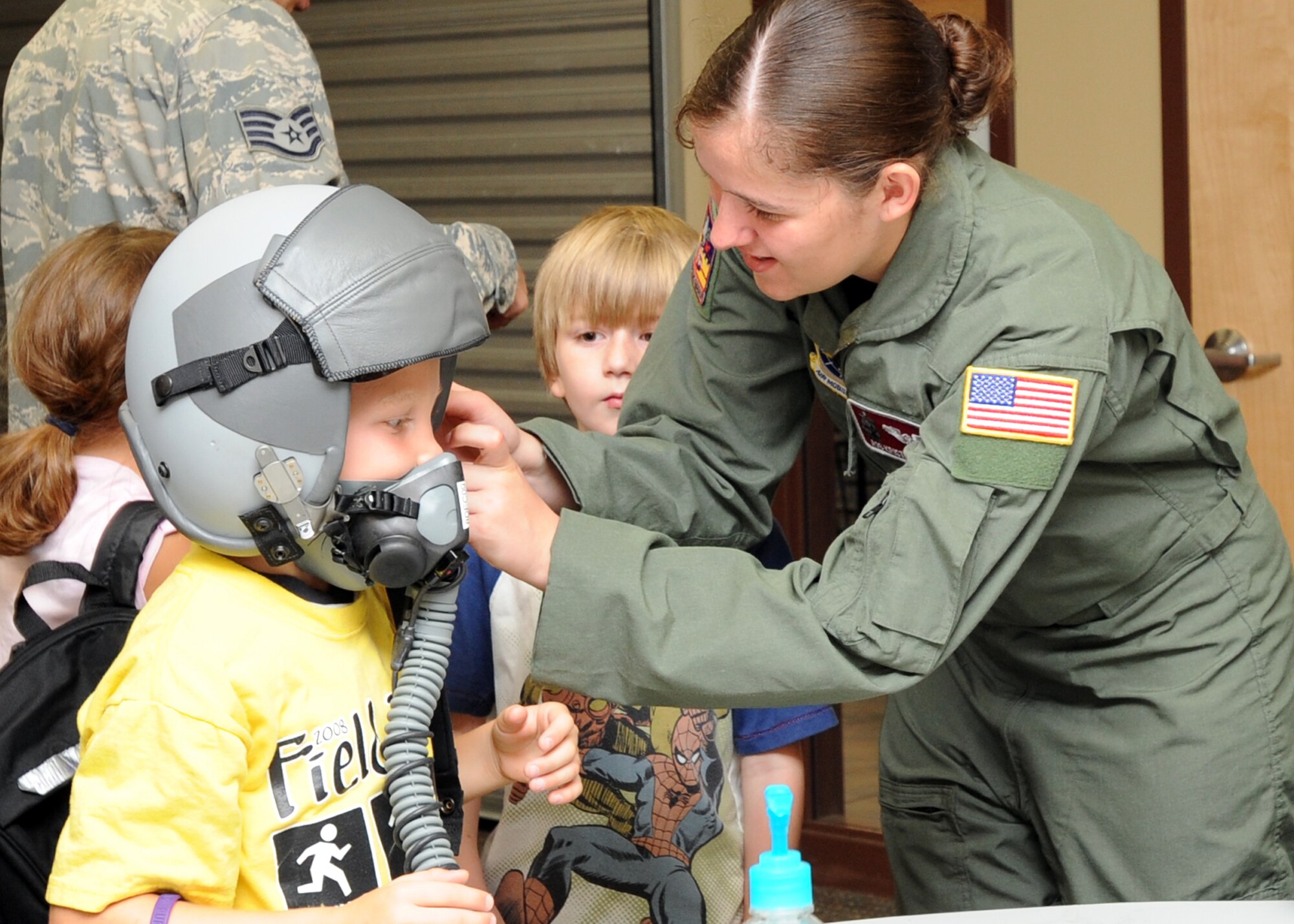 Airman 1st Class Kristin Bailey, 384th Air Refueling Squadron boom operator, straps a flight helmet on Jeremy Pruitt, an 8 year old from Camp Wood Young Men Christian Association’s summer program during military theme day Aug. 10, 2010, Flint Hills, Kan.  Airmen from Team McConnell volunteered to teach campers about the many aspects of the Air Force such as aircrew flight equipment, mobility readiness equipment, in-flight refueling procedures and Honor Guard.  The camp is sponsored by the National Military Family Association and offers a free week of camp for the children of active-duty military personnel.  (U.S. Air Force photo/Airman 1st Class Andrea Salazar)