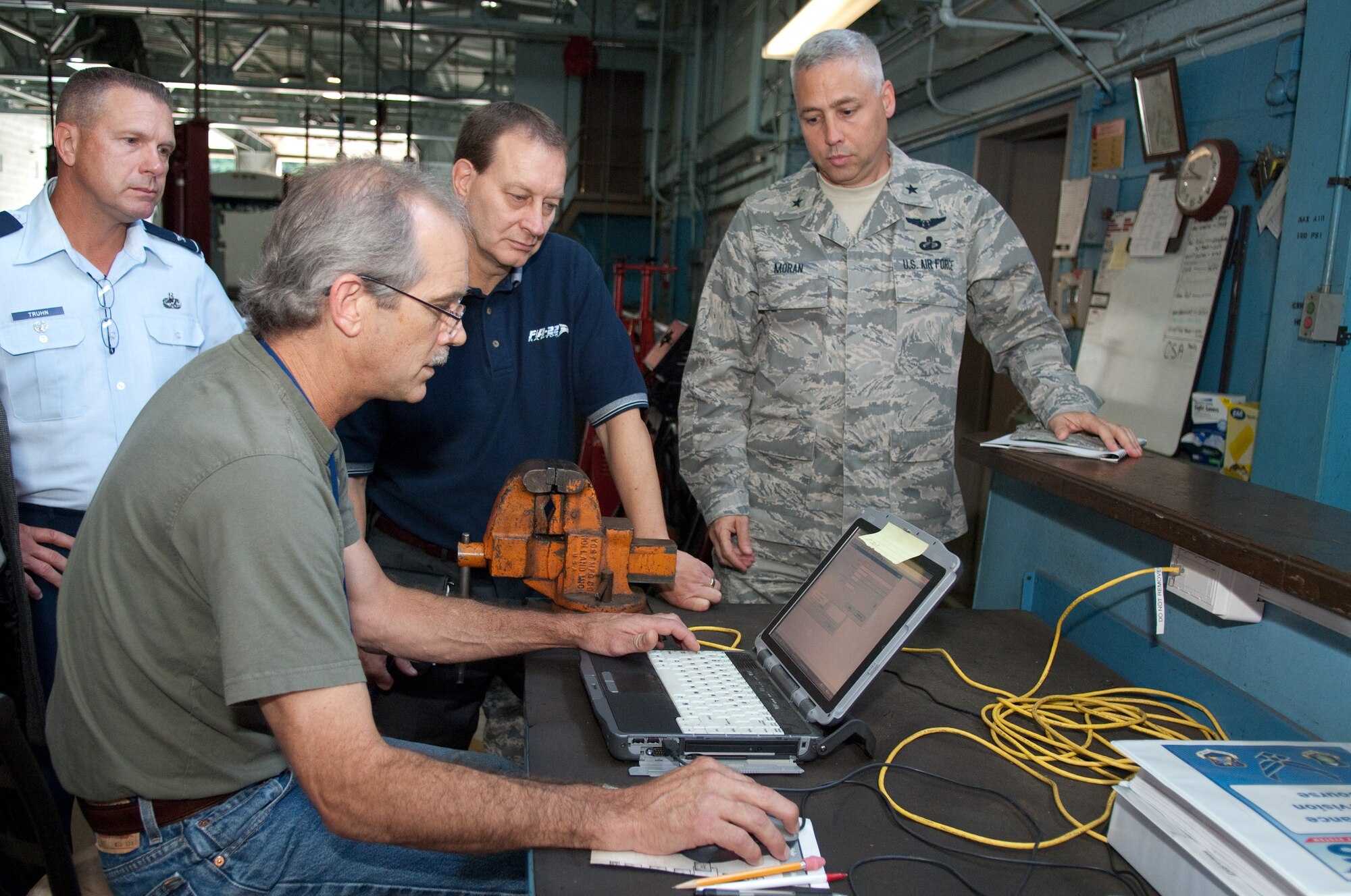 Pat Justvig, maintenance flight work leader in the 66th Logistics Squadron, demonstrates the Expeditionary Combat Support System to (left to right)  Col. Harry Truhn, director of Logistics for the Air National Guard at Andrews AFB, Md., Ross Marshall, deputy director of Logistics for Air Force Materiel Command, and Brig. Gen. Kenneth J. Moran, ECSS program executive officer, Aug. 17.   ECSS champions from most Air Force major commands, along with program officials, spent two days at Hanscom, the pilot base for ECSS implementation, for a Functional Executive Steering Group meeting.  Along with briefings, participants toured the maintenance flight and got direct feedback from the men and women who have been using the system since the program went live Aug. 2.  (U.S. Air Force photo by Rick Berry)