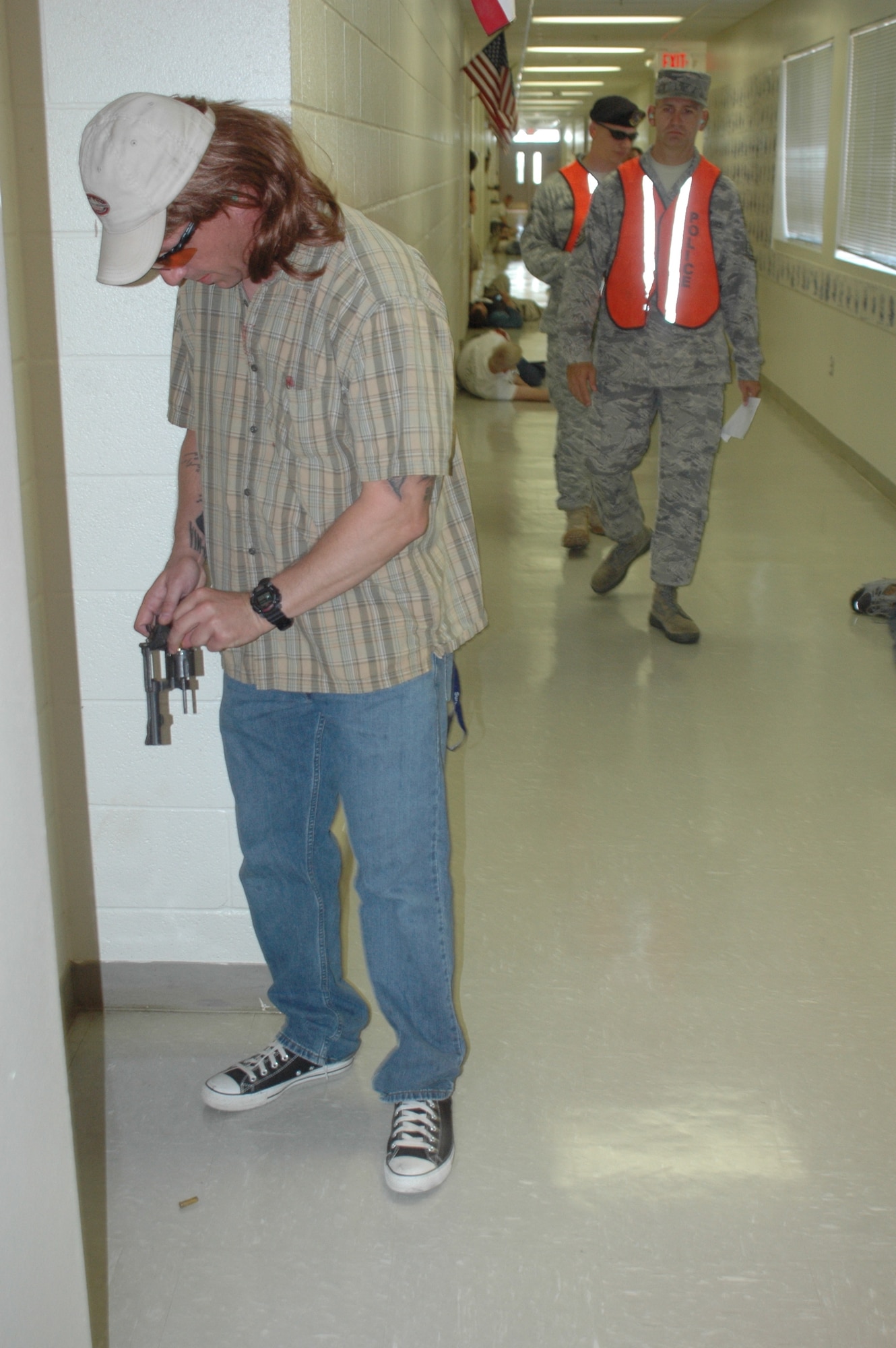 Tech. Sgt. Charles Fortier, 377th Security Forces Squadron, reloads his weapon while evaluators monitor the situation during an active-shooter exercise July 31 inside Sandia Base Elementary.  U.S. Air Force Photo by Jonathan Rejent