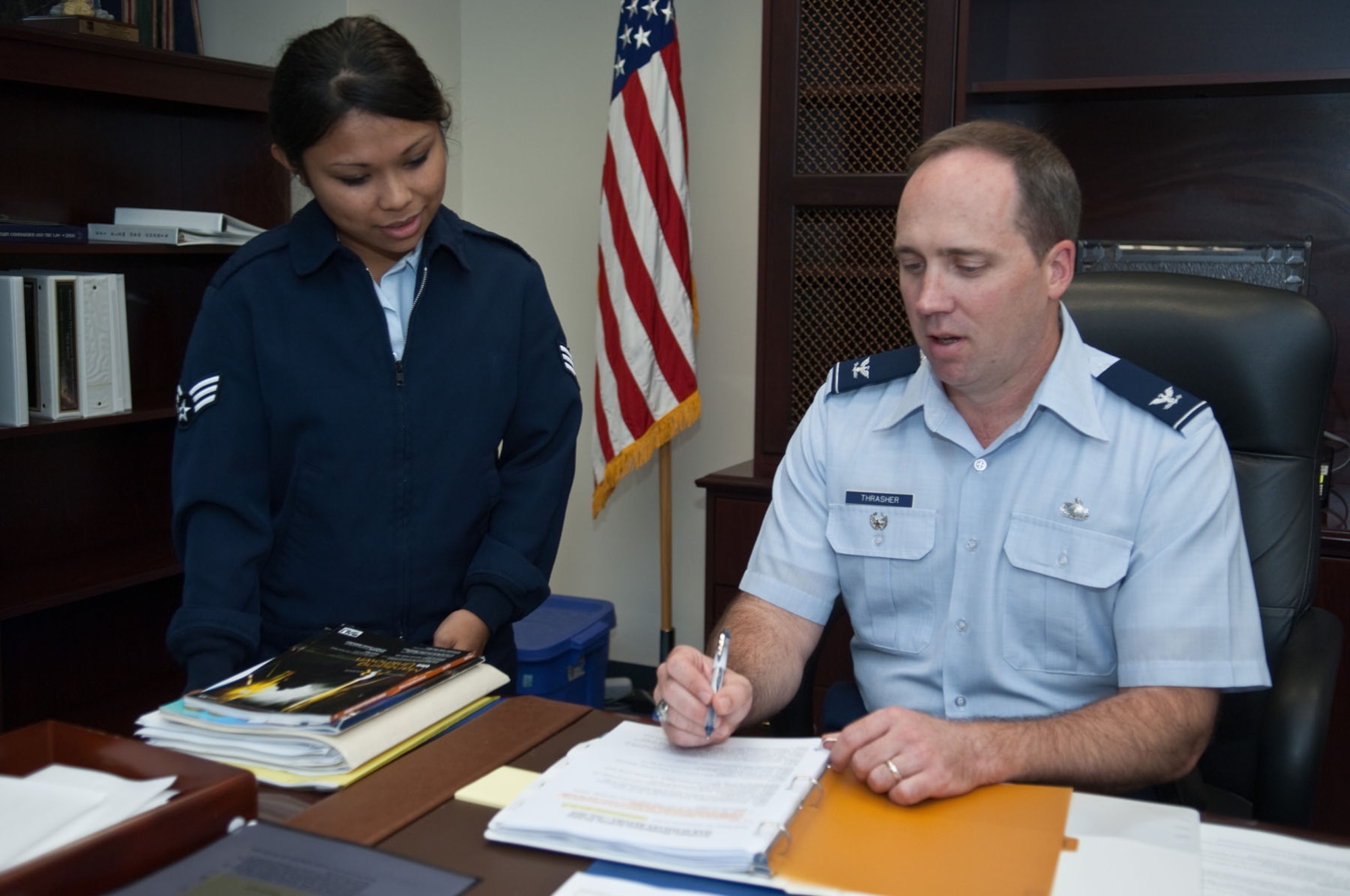 HANSCOM AIR FORCE BASE, Mass. - Col. Roger D. Thrasher, program executive officer for Battle Management, discusses an activity report with Senior Airman Maria Alma Javines, knowledge operations manager, on Aug. 16. (U.S. Air Force photo by Rick Berry) 