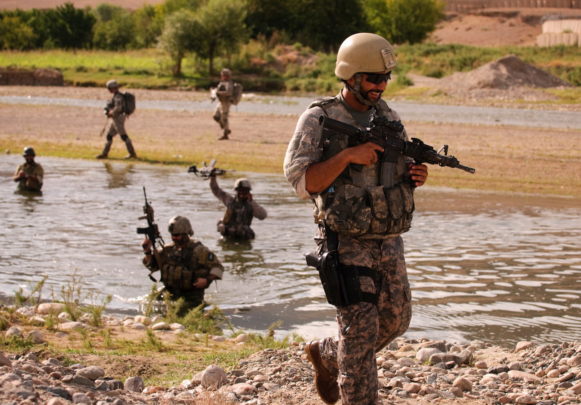 FORWARD OPERATING BASE LANE, Afghanistan -- U.S. Army Cpl. Alberto Bhoge, Charlie Company, 478th Civil Affairs Battalion, laughs after crossing a river during a dismounted patrol near Forward Operating Base Lane, Zabul province, Aug. 6. (U.S. Air Force photo/Senior Airman Nathanael Callon)