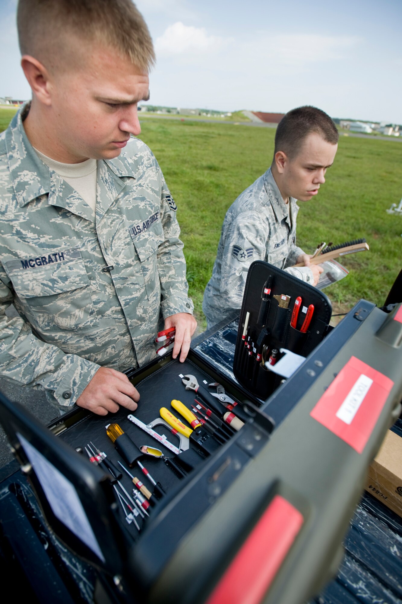 MISAWA AIR BASE, Japan -- Staff Sgt. James McGrath (left) and Senior Airman Kevin Finstuen, 35th Communications Squadron airfield-systems maintenance technicians, prepare their corrosion kits Aug. 17 on the flightline. The Airmen provide quality maintenance for weather systems, ground-based navigation systems and ground-air radio systems used by all U.S., Japan Air Self-Defense Force and commercial aircrafts that come through Misawa. (U.S. Air Force photo/Senior Airman Jamal D. Sutter)