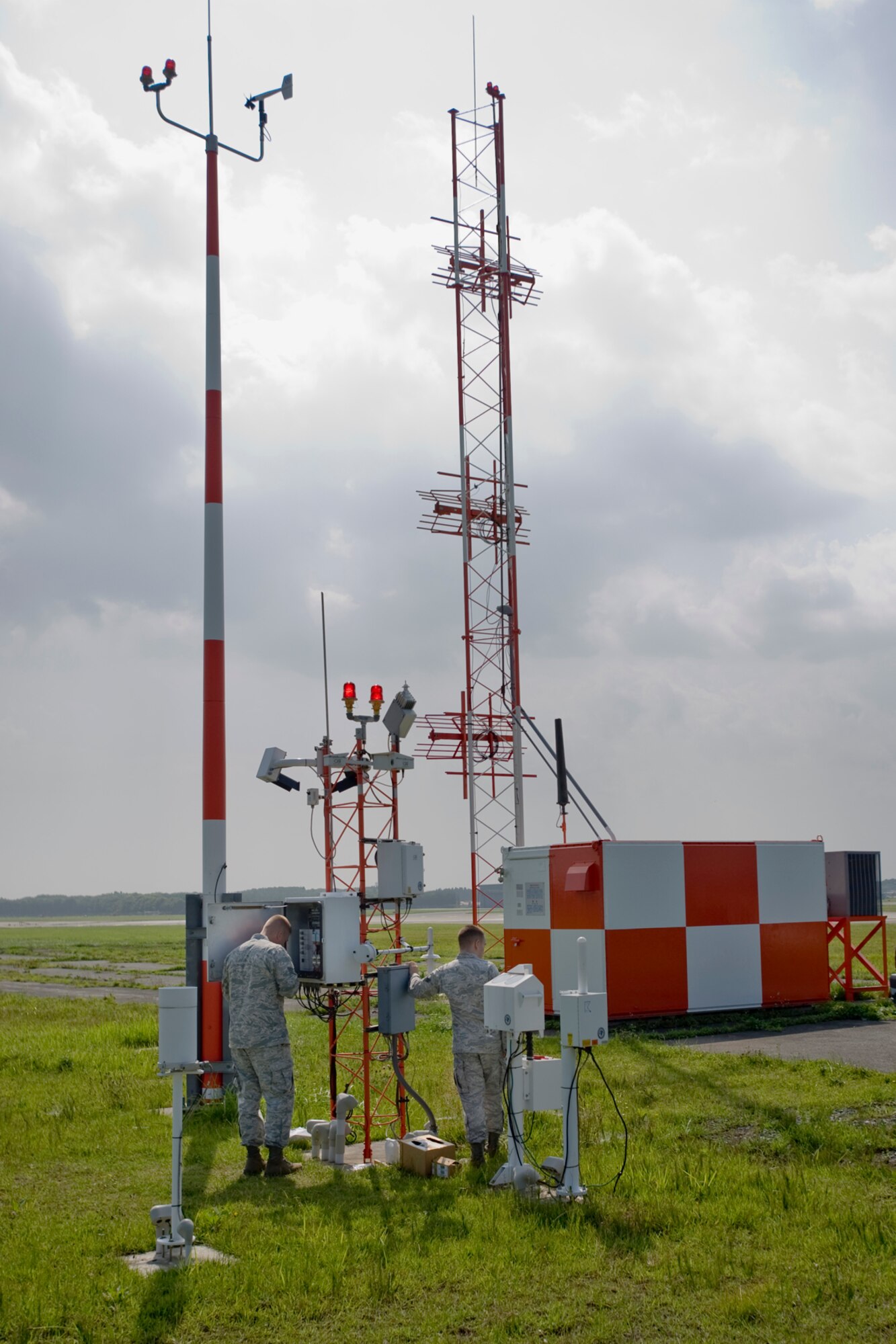 MISAWA AIR BASE, Japan -- Staff Sgt. James McGrath (left) and Senior Airman Kevin Finstuen, 35th Communications Squadron airfield-systems maintenance technicians, conduct maintenance on an automatic observation system Aug. 17 on the flightline. Due to extreme humidity during Misawa's summer season, airfield-systems maintenance performs frequent corrosion control checks on weather stations and other equipment. (U.S. Air Force photo/Senior Airman Jamal D. Sutter)