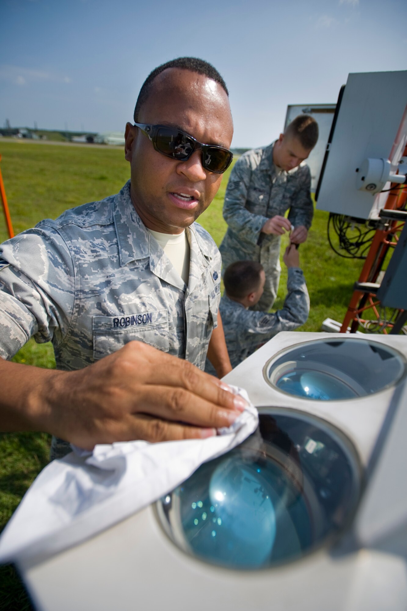 MISAWA AIR BASE, Japan -- Tech. Sgt. Linwood Robinson, 35th Communications Squadron airfield-systems maintenance NCO in charge, wipes a laser ceilometer Aug. 17 on the flightline. A laser ceilometer is a device used to measure cloud height, thickness and vertical visibility. Any dirt or residue present on the covering can interfere with the laser and create false readings. (U.S. Air Force photo/Senior Airman Jamal D. Sutter)