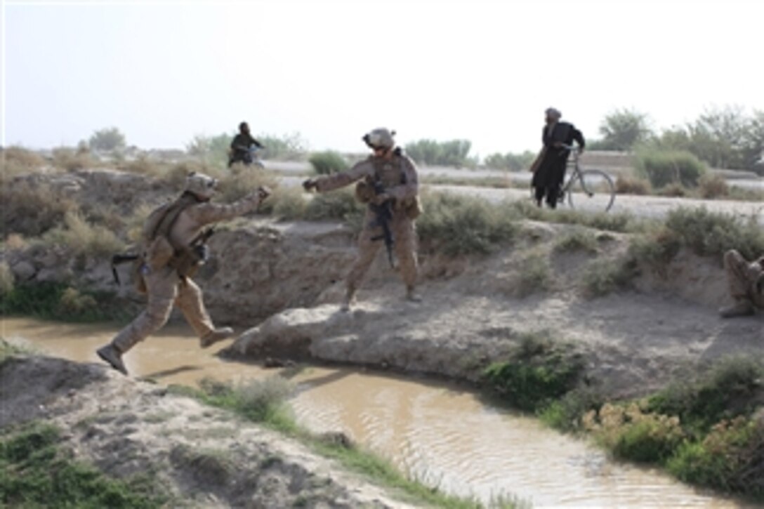 U.S. Marines with Headquarters and Service Company, 3rd Battalion, 1st Marine Regiment, Regimental Combat Team 7 jump across a canal during a patrol outside Forward Operation Base Delhi, Helmand province, Afghanistan, on Aug. 10, 2010.  The Marines are deployed to the province to support the International Security Assistance Force.  