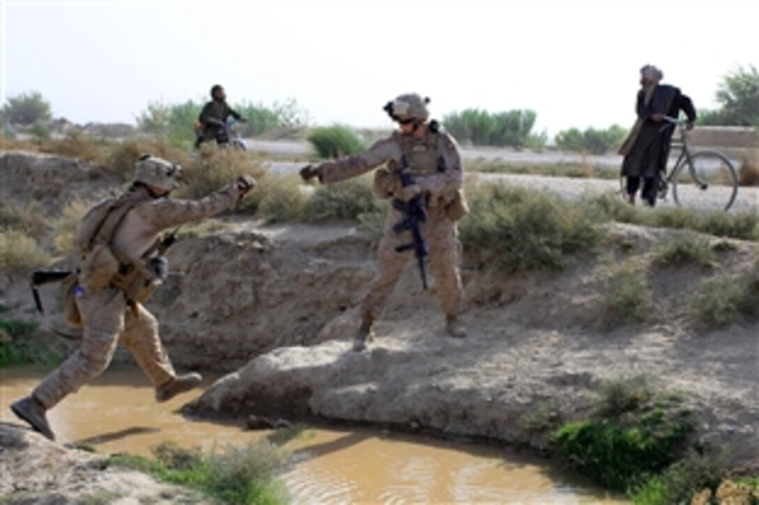 U.S. Marines jump across a canal during a patrol outside of Forward Operation Base Delhi, Afghanistan, Aug. 10, 2010. The Marines, assigned to Headquarters and Service Company, 3rd Battalion, 1st Marine Regiment, Regimental Combat Team 7, regularly conduct patrols in order to show a presence in the area.
