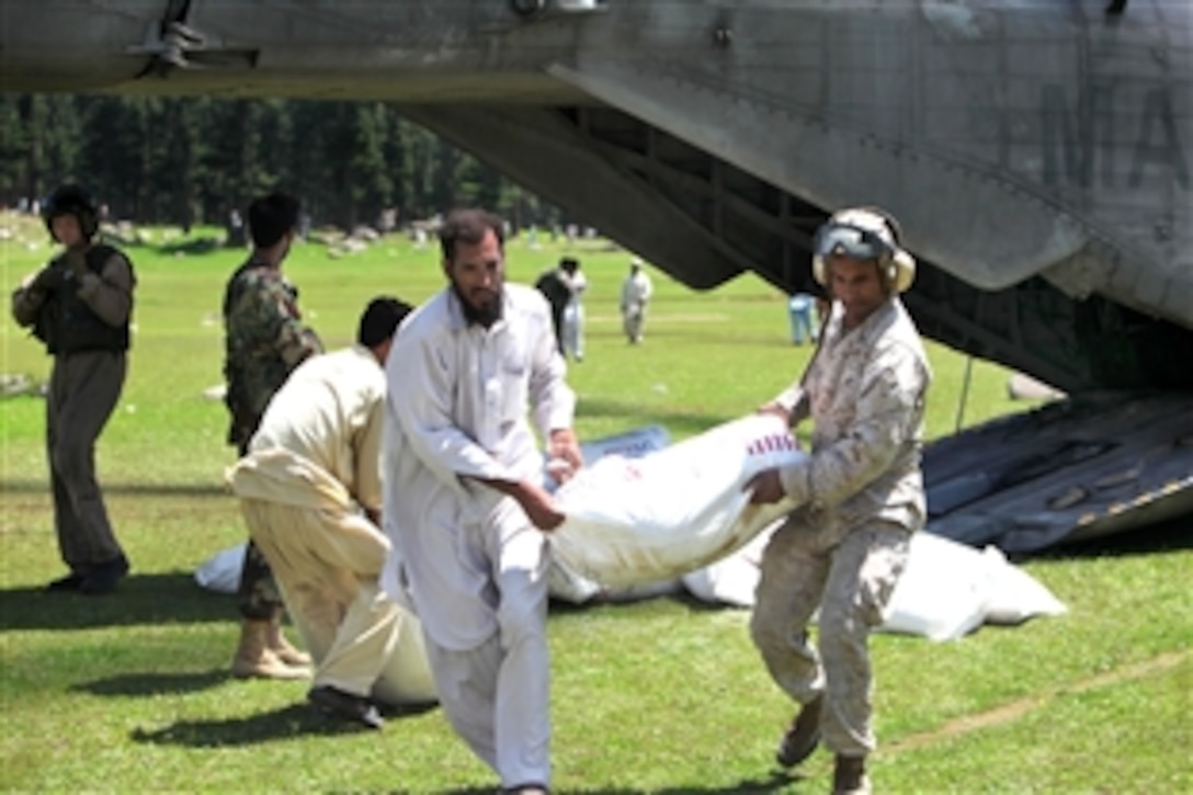 U.S. Marine Corps Capt. Paul Duncan helps Pakistani civilians unload a CH-53E Super Stallion helicopter attached to the HM-165, 15th Marine Expeditionary Unit, during humanitarian relief efforts in the Khyber-Pakhtunkhwa province, Pakistan, Aug. 18, 2010. Duncan is assigned to the 15th Marine Expeditionary Unit Public Affairs.