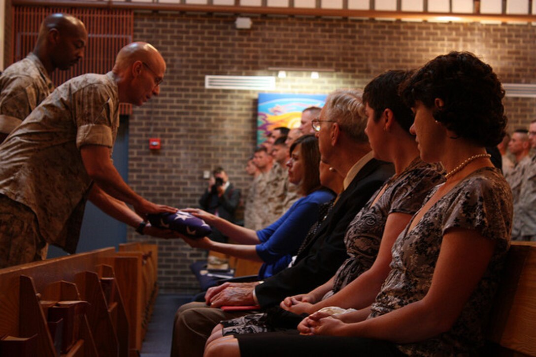 Col. Gerard F. Fischer, commanding officer for the 4th Civil Affairs Group, and Sgt. Maj. O'Neal Johnson, the group's sergeant major, present the American flag to Sgt. Bill Cahir's family at a memorial service dedicated to him. Sgt. Bill Cahir was KIA on August 13, 2009 in the Nawa, Afghanistan while serving with the 4th Civil Affairs Group in Operation Enduring Freedom.