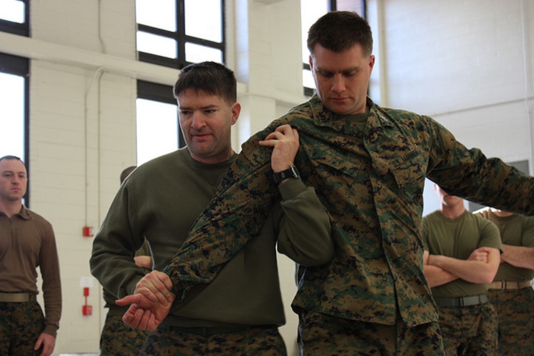 While demonstrating a martial arts move, Capt. Randy Stone is restrained while Capt. Brian Humphreys teaches the group basic Marine Corps Martial Arts Program techniques. The 4th Civil Affairs Group got training in all Marine Corps common skills despite only meeting once-a-month.