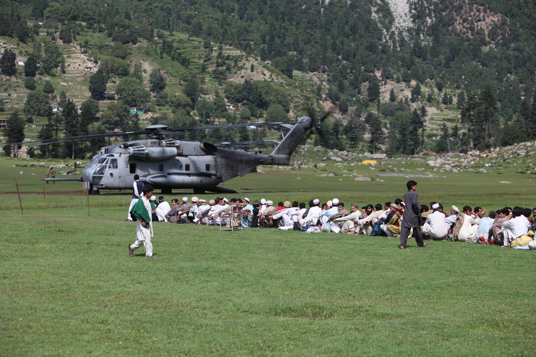 Pakistani civilians wait to board a Corps Super Stallion helicopter during humanitarian relief efforts in the Khyber-Pakhtunkhwa province, Pakistan(formerly known as the Northwest Frontier province, Pakistan).
