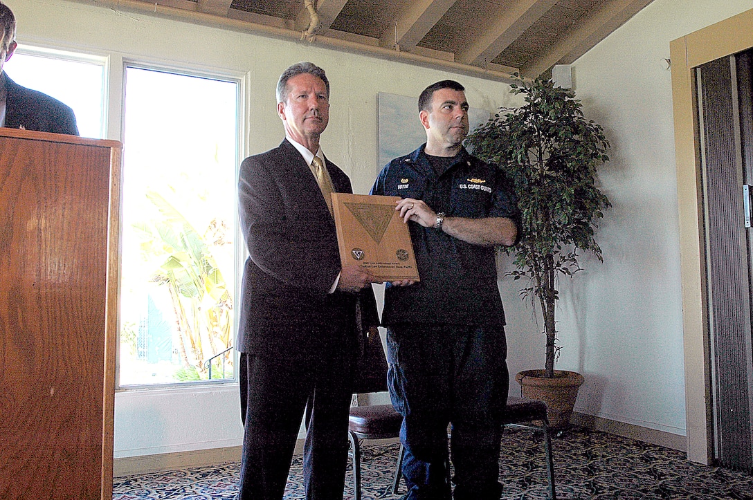 Patrick Ward, left, acting deputy director for supply reduction and United States interdiction coordinator, presents Cmdr. Jon Totte, commanding officer, pacific tactical law enforcement team, with the 2009 United States Interdiction Coordinator Award to the Coast Guard PACTACLET at the Bay View Restaurant, here, Aug. 19. The award was established to recognize superior performance of front-line narcotics interdictors in the ongoing battle against drug smugglers and the organizations that support them.