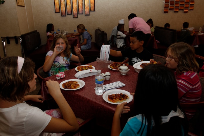 Camp Adventure children enjoy pizza they made during a food pyramid class at JD’s Grille here Aug. 19. Ginnna Benke, JD’s Grille executive chef, taught the children the value of nutrition and a healtful diet. Benke said she used pizza as the teaching tool because it involves almost every food group in the food pyramid and makes it easier to discuss the value of nutrition with the children.