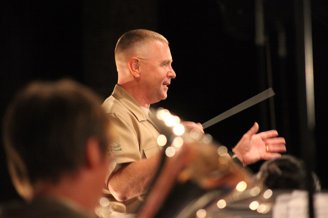 Gunnery Sgt. Richard Nunley, the enlisted conductor for the Combat Center Band, breaks a smile as the band crescendos.