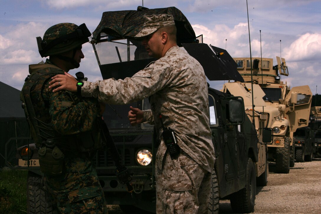 U.S. Marine Gunnery Sgt. William Willis, operations chief with 6th Marine Regiment, ensures a solider with The Republic of Georgia's 32nd Light Infantry Battalion is prepared for a convoy to a mock forward operating base during the mission rehearsal exercise at the Joint Multinational Readiness Center here, Aug 19.  The MRE will serve as a final evaluation of the 32nd LIB as they prepare for their deployment to Afghanistan in support of International Security Assistance Forces there.