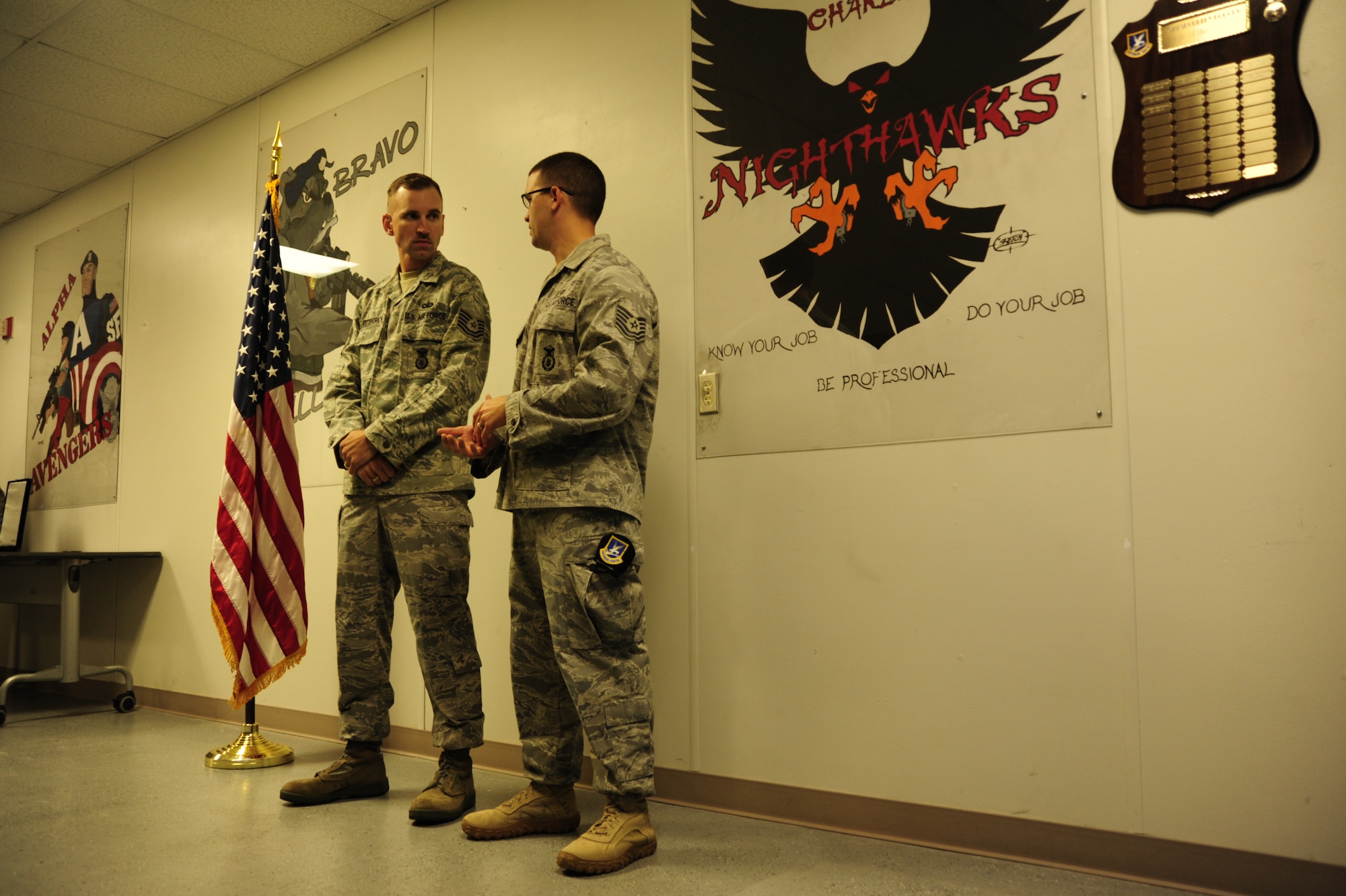 Technical Sgts. Steven Ostrander and Robert Fitzpatrick, both assigned to the 62nd Security Forces Squadron, quietly talk before a Bronze Star ceremony Aug. 19. Sergeants Ostrander and Fitzpatrick received the medal for their leadership, thinking and knowledge during their deployments in support of Operation Iraqi Freedom. (U.S. Air Force Photo/Airman Leah Young)