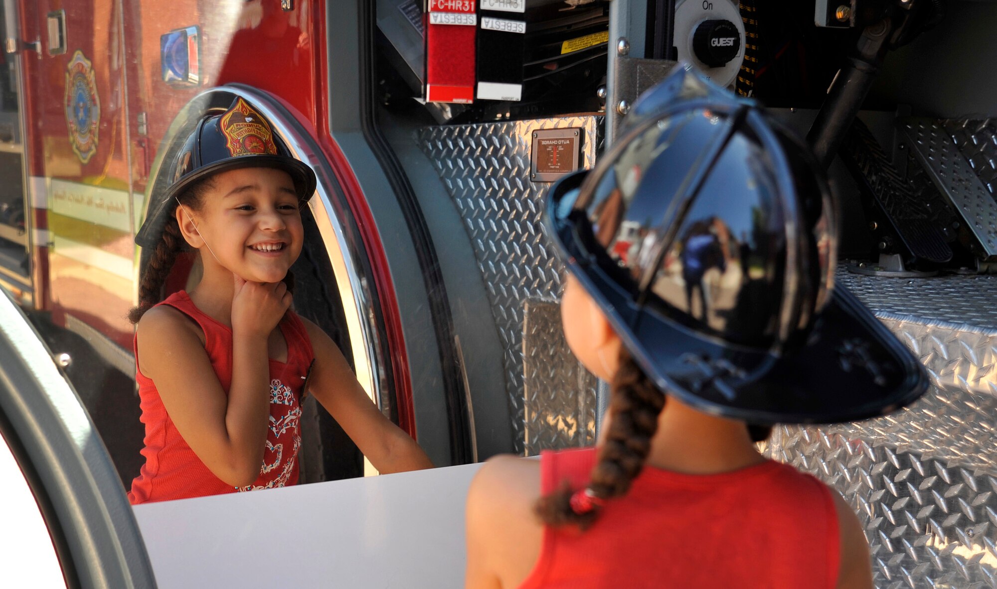 Billie Evans looks at her reflection in a chrome panel of one of the fire trucks on display at the Air Force Academy Fire Department's open house Aug. 14, 2010, at Fire Station 1. (U.S. Air Force photo/Bill Evans)