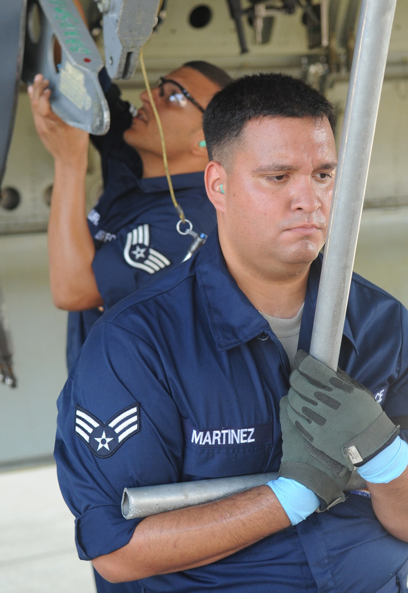 (Front) Senior Airman Francisco Martinez, member of the 2d Aircraft Maintenance Squadron weapons load crew, helps hold up the bomb bay door of a B-52H Stratofortress as Staff Sgt. Jose Baez-Sauri, also a weapons load crew member, puts the holding pins in place during the weapons load portion of the Global Strike Challenge Aug. 17. More than 400 Airmen from 2d Bomb Wing and B-52 Stratofortress were able to compete in this year?s challenge. (U.S. Air Force photo/Senior Airman Amber Ashcraft) (RELEASED)